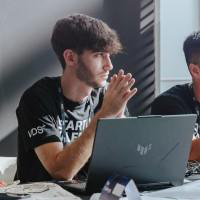 Sergio Sabater Ruiz, sitting at an open laptop, hands together as he listens.